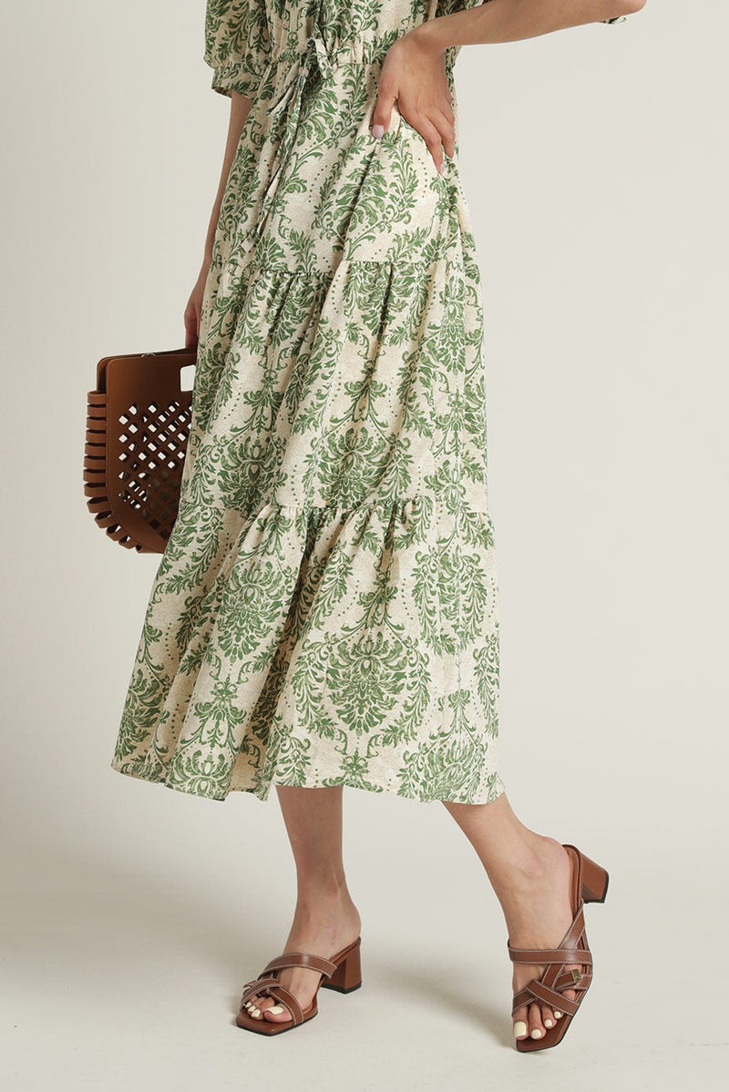 Lady wearing green floral calf length rayon dress
