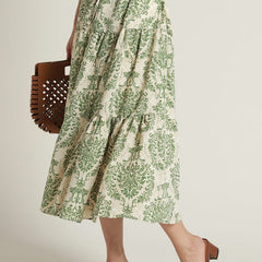 Lady wearing green floral calf length rayon dress
