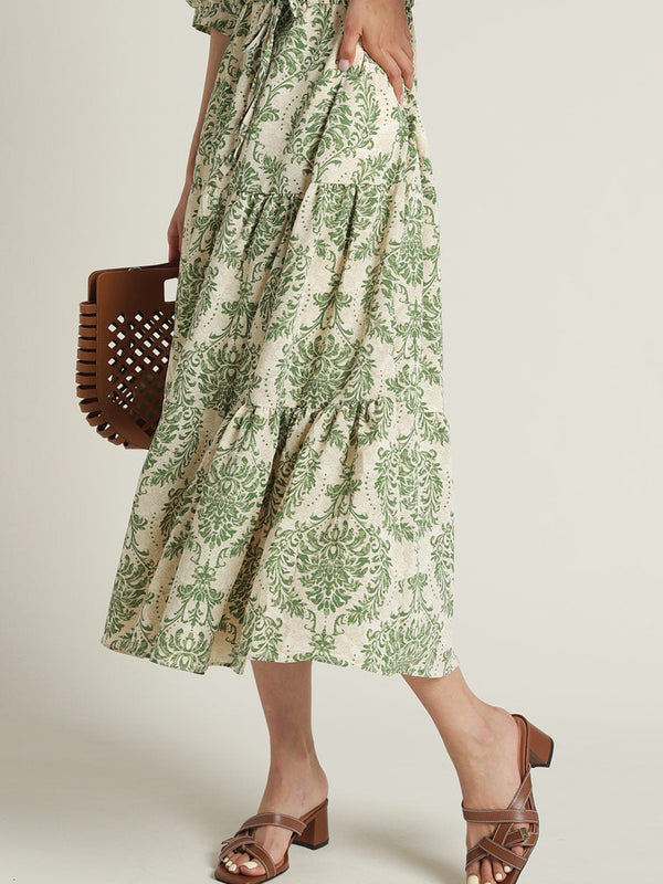 Lady wearing green floral calf length rayon dress
